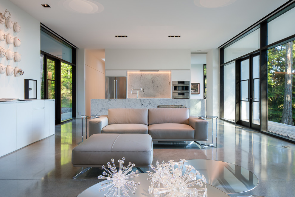 На фото: открытая гостиная комната в стиле модернизм с белыми стенами, бетонным полом и серым полом с