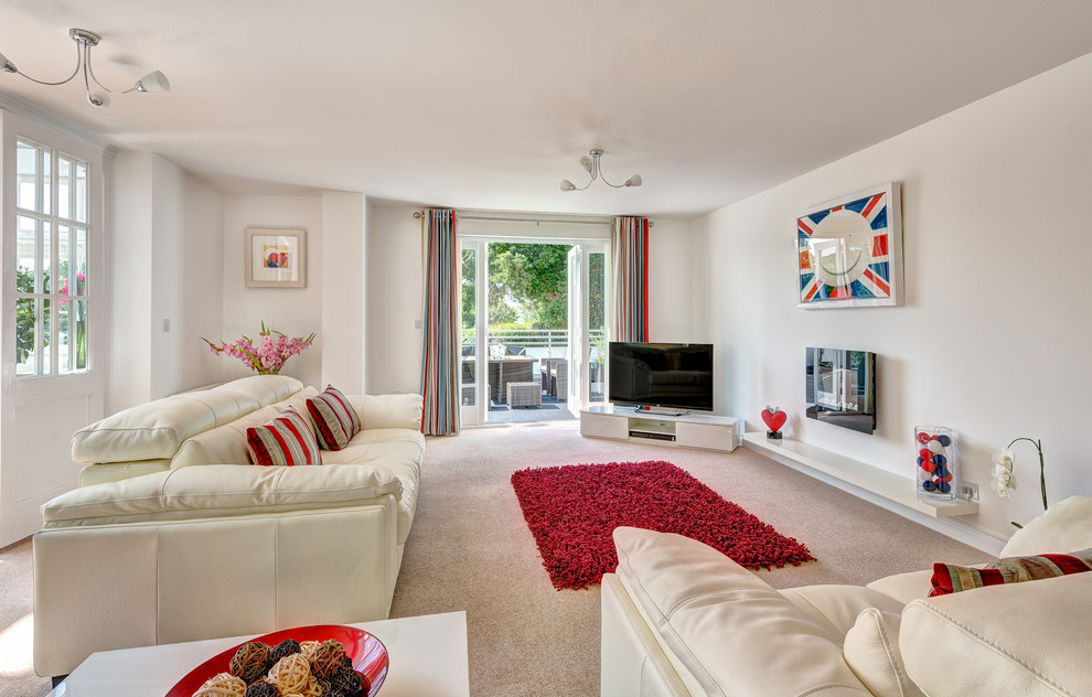Modernes Wohnzimmer mit weißer Wandfarbe, Teppichboden und freistehendem TV in Devon