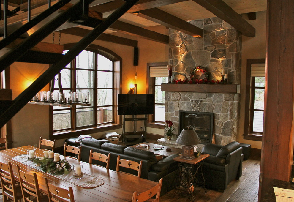 Foto de salón abierto rústico con paredes beige, suelo de madera en tonos medios, todas las chimeneas, marco de chimenea de piedra y televisor independiente