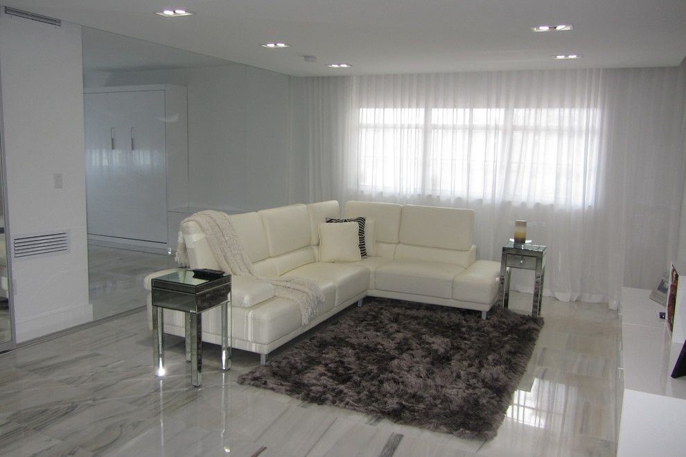 Ejemplo de salón abierto actual de tamaño medio sin chimenea con paredes grises, suelo de mármol, televisor colgado en la pared y suelo gris