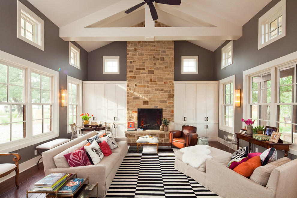 Источник вдохновения для домашнего уюта: огромная гостиная комната в современном стиле с серыми стенами, стандартным камином и фасадом камина из камня без телевизора