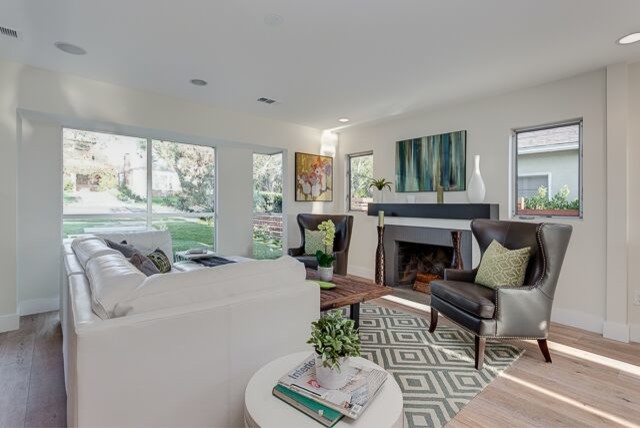 Inspiration for a large contemporary open concept light wood floor living room remodel in Los Angeles with white walls, a standard fireplace, a tile fireplace and no tv
