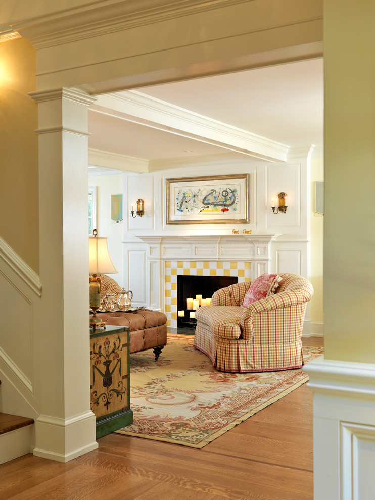 Elegant medium tone wood floor living room photo in Boston with a standard fireplace and a tile fireplace