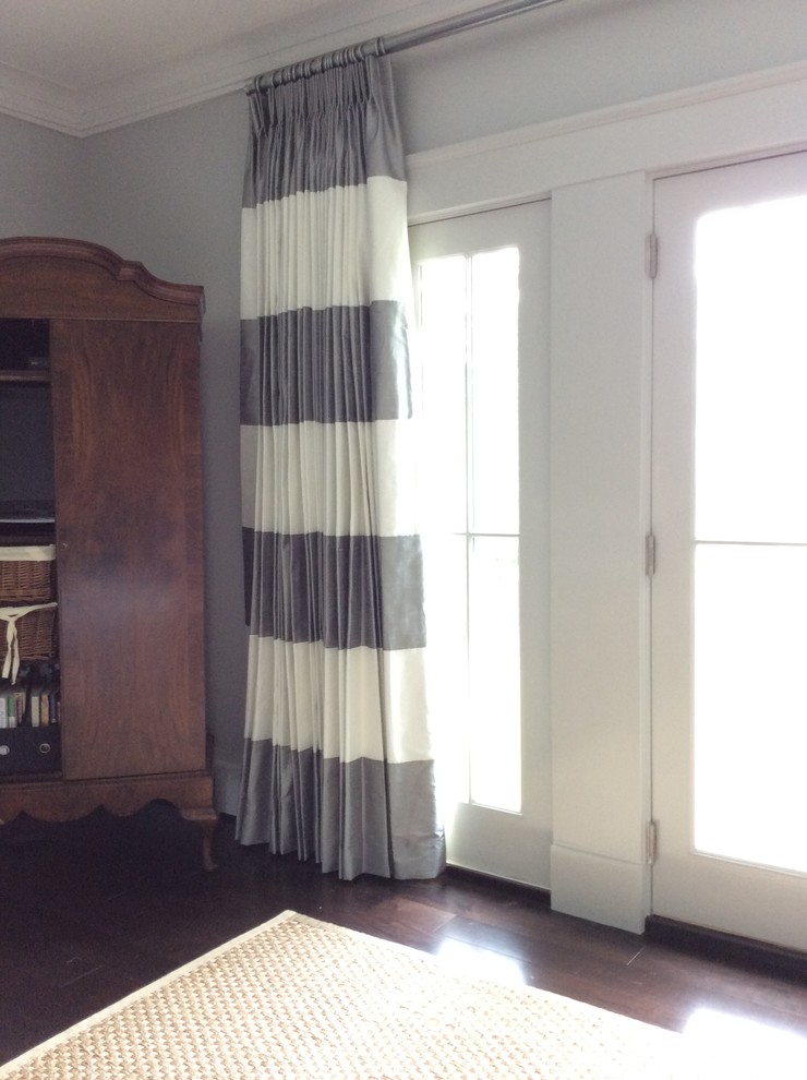 На фото: изолированная гостиная комната среднего размера в классическом стиле с серыми стенами, темным паркетным полом, скрытым телевизором и коричневым полом без камина