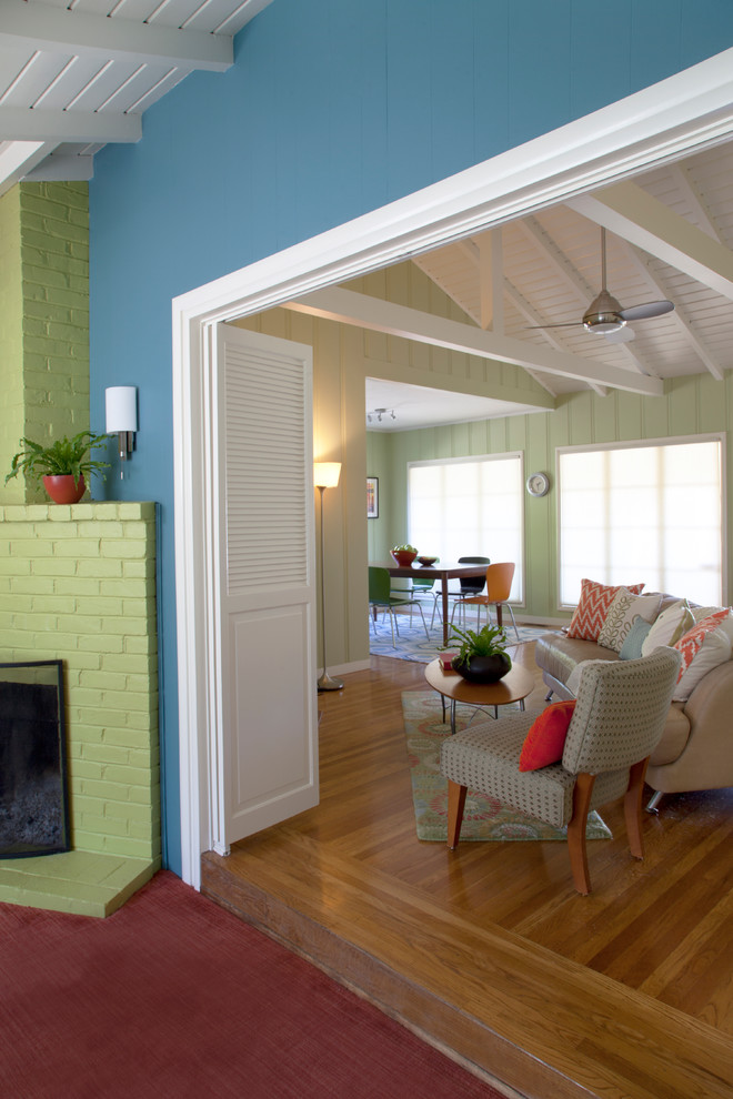 Стильный дизайн: гостиная комната среднего размера в морском стиле с зелеными стенами, паркетным полом среднего тона, угловым камином и фасадом камина из кирпича - последний тренд