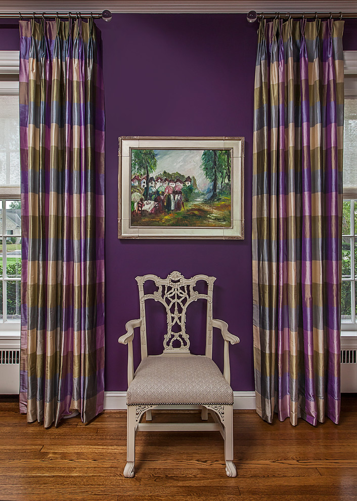 Cette image montre un grand salon bohème fermé avec une salle de réception, un mur violet, parquet foncé, une cheminée double-face, un manteau de cheminée en béton, aucun téléviseur et un sol marron.