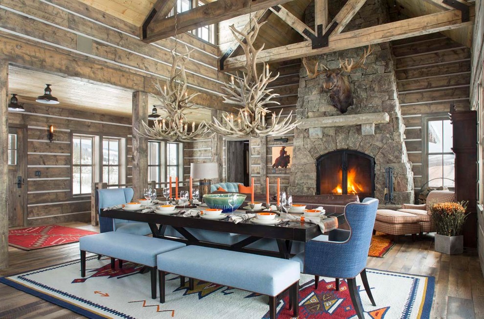 Large rustic mezzanine living room in Denver with a home bar, brown walls, dark hardwood flooring, a standard fireplace, a stone fireplace surround and no tv.