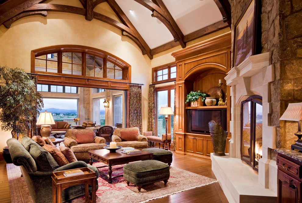 Inspiration for a large mediterranean living room in Denver with medium hardwood flooring, a standard fireplace and a stone fireplace surround.