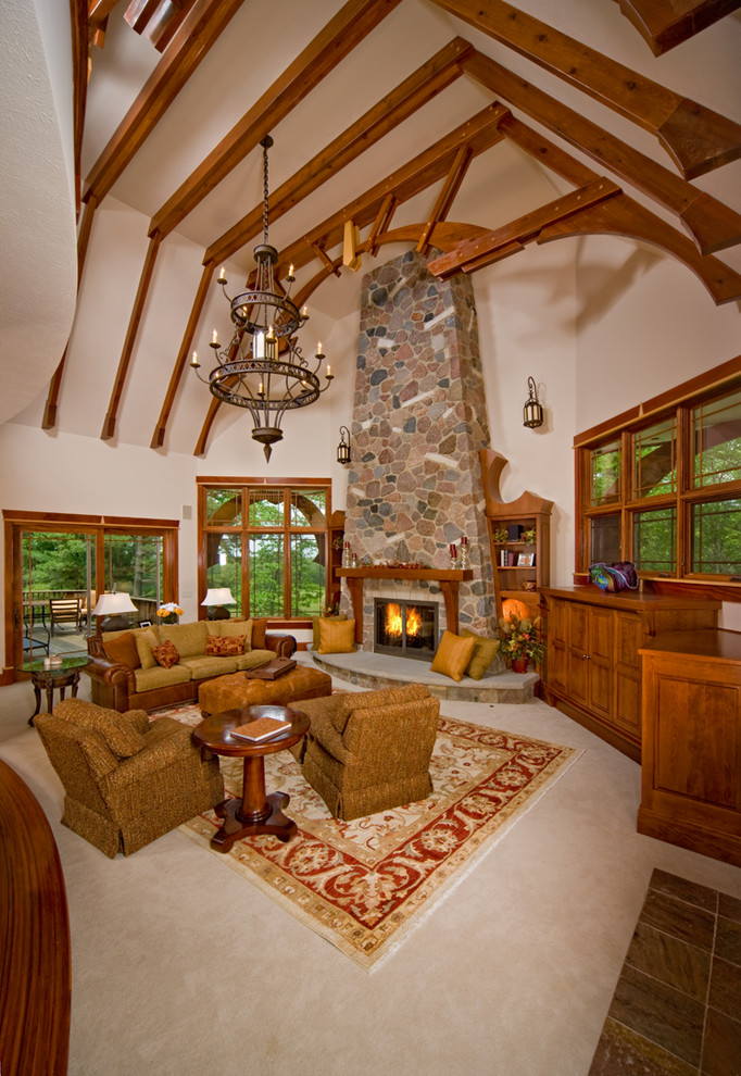 Example of a large mountain style carpeted living room design in Chicago with a standard fireplace, a stone fireplace and a concealed tv