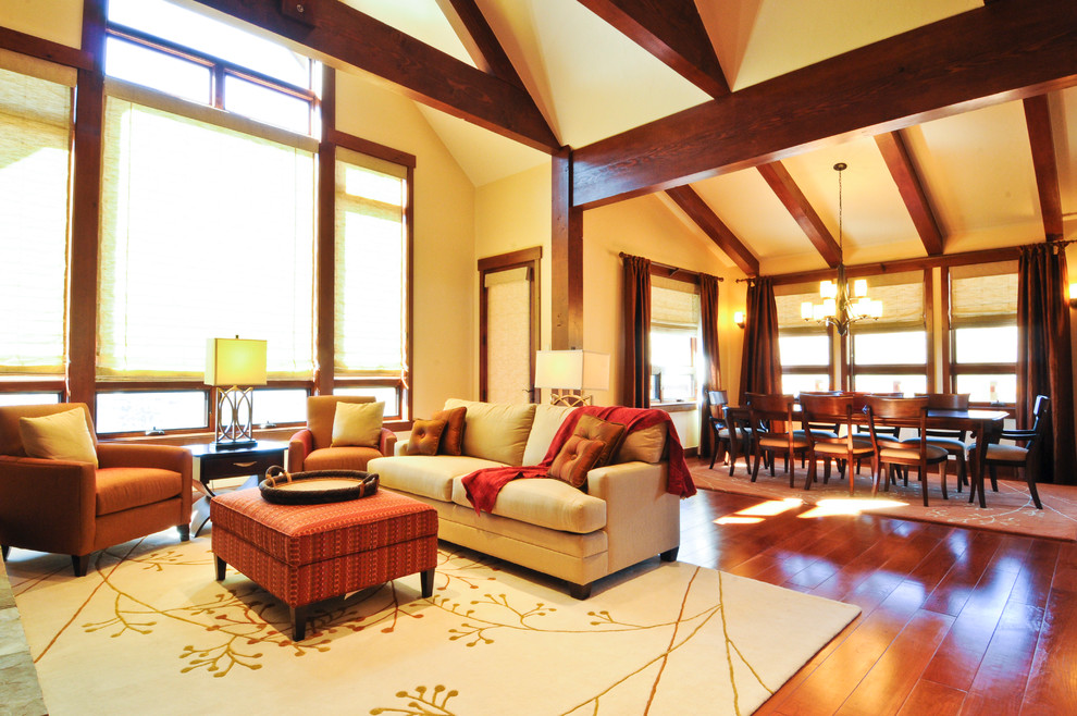 Aménagement d'un grand salon montagne ouvert avec une salle de réception, un sol en bois brun et un sol marron.