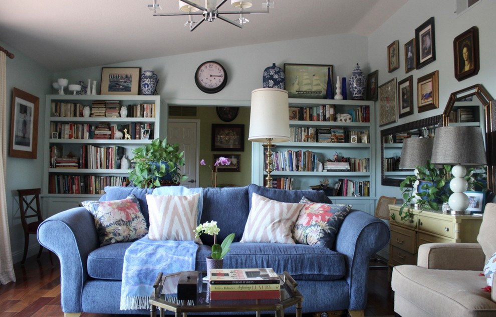 Inspiration for a mid-sized eclectic enclosed dark wood floor and brown floor living room library remodel in San Diego with blue walls, a standard fireplace, a stone fireplace and a tv stand