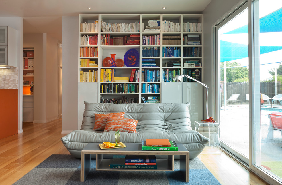 Свежая идея для дизайна: гостиная комната в стиле ретро с с книжными шкафами и полками и светлым паркетным полом - отличное фото интерьера
