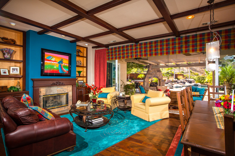 Großes, Fernseherloses, Offenes Mediterranes Wohnzimmer mit beiger Wandfarbe, braunem Holzboden, Kamin und Kaminumrandung aus Stein in San Diego