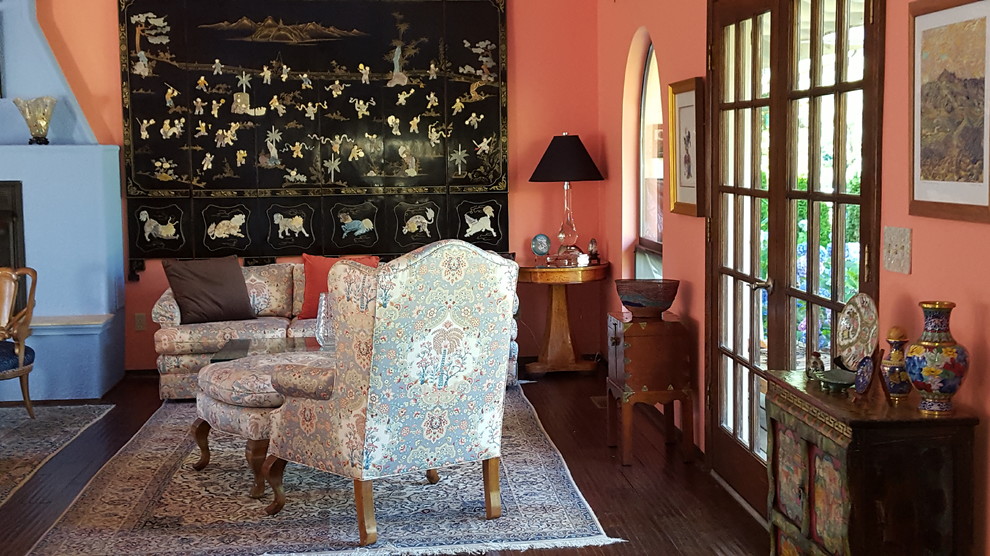 Esempio di un grande soggiorno bohémian aperto con pareti multicolore, parquet scuro, camino classico e cornice del camino in intonaco