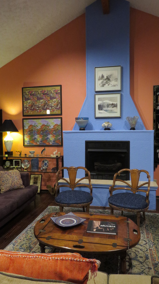 Immagine di un grande soggiorno eclettico aperto con pareti multicolore, parquet scuro, camino classico e cornice del camino in intonaco