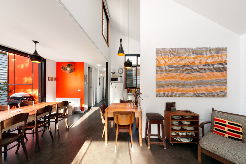 Foto på ett mellanstort funkis vardagsrum, med orange väggar, betonggolv och grått golv