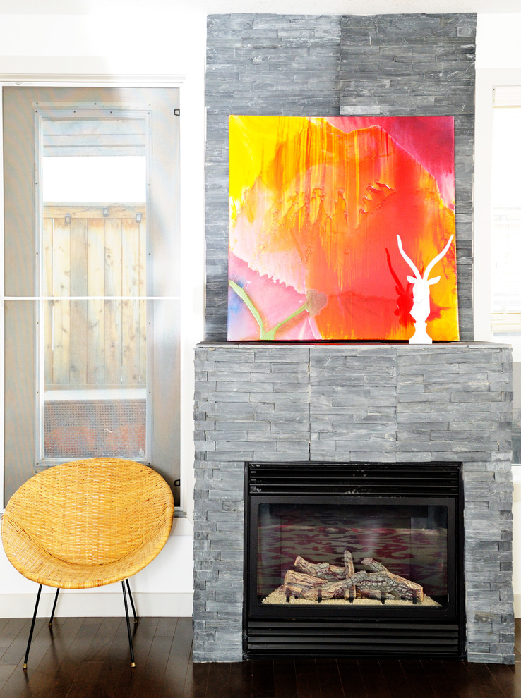 Mittelgroßes, Offenes, Repräsentatives Stilmix Wohnzimmer mit Kamin, weißer Wandfarbe, braunem Holzboden, Kaminumrandung aus Stein und braunem Boden in Calgary