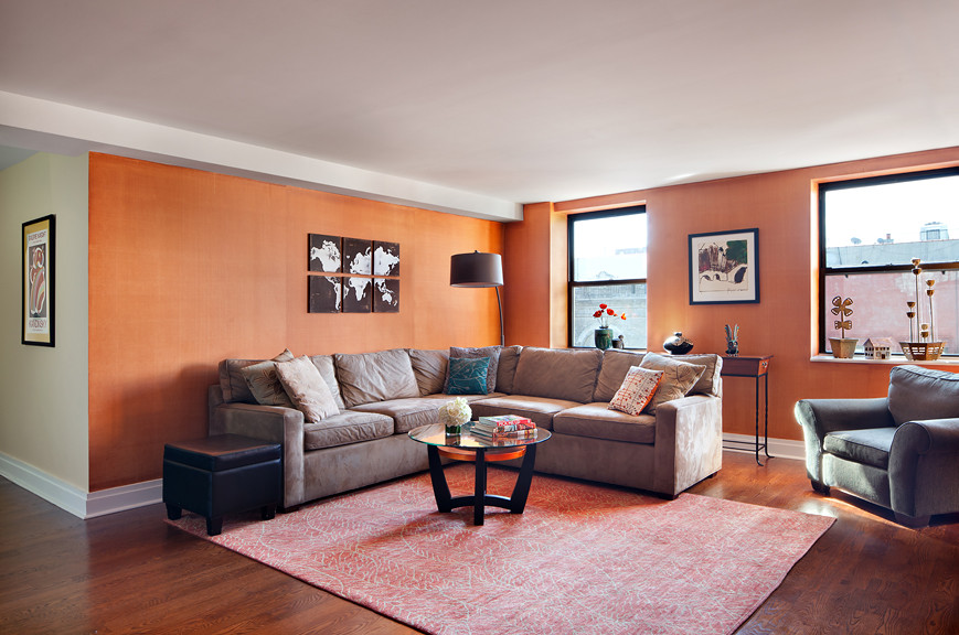 На фото: открытая гостиная комната среднего размера в стиле неоклассика (современная классика) с оранжевыми стенами, паркетным полом среднего тона и телевизором на стене без камина с