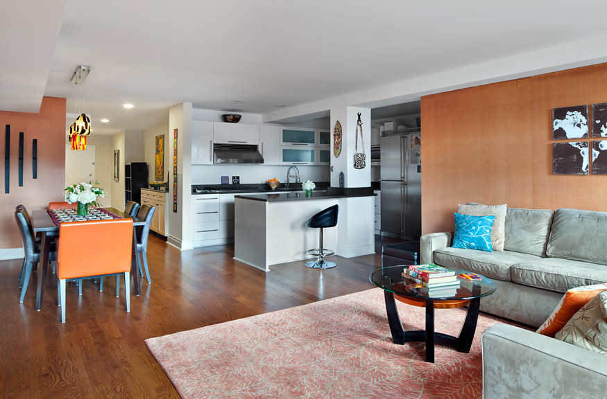Идея дизайна: открытая гостиная комната среднего размера в стиле неоклассика (современная классика) с оранжевыми стенами, паркетным полом среднего тона и телевизором на стене без камина