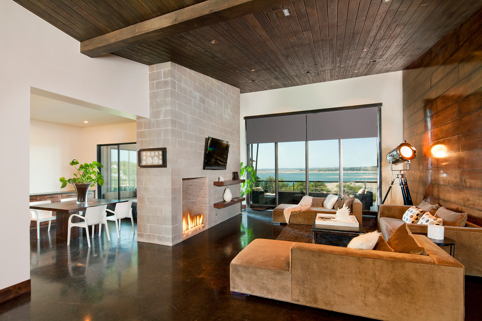 Inspiration for a contemporary living room in Austin with concrete flooring and a wall mounted tv.