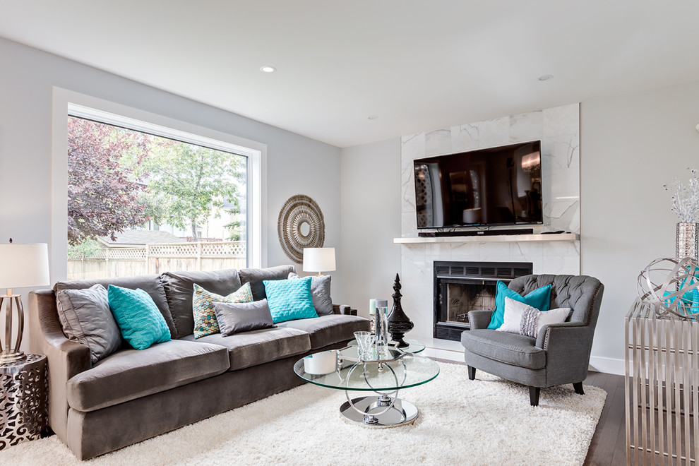 Large traditional grey and teal open plan living room in Calgary with blue walls, carpet, a standard fireplace, a stone fireplace surround and a wall mounted tv.