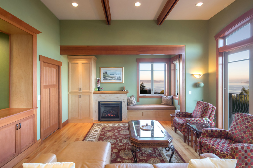 На фото: открытая гостиная комната среднего размера в стиле кантри с зелеными стенами, стандартным камином, фасадом камина из камня и светлым паркетным полом без телевизора с