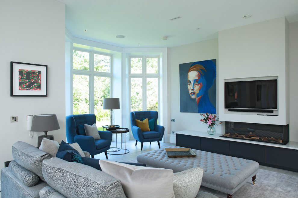 На фото: гостиная комната в современном стиле с белыми стенами, горизонтальным камином, телевизором на стене и эркером