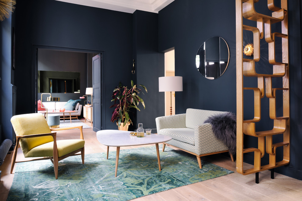 Modern inredning av ett vardagsrum, med ett finrum, ljust trägolv och blå väggar