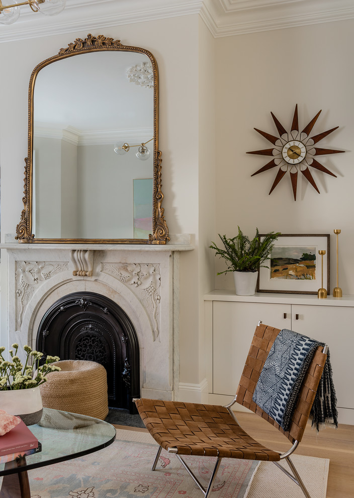 Diseño de salón clásico renovado con paredes beige, suelo de madera clara, todas las chimeneas y suelo beige