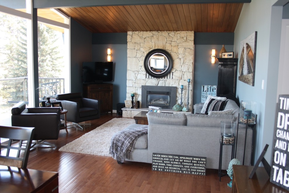 Geräumiges, Repräsentatives, Offenes Modernes Wohnzimmer mit grüner Wandfarbe, braunem Holzboden, Kamin, Kaminumrandung aus Stein und Eck-TV in Vancouver