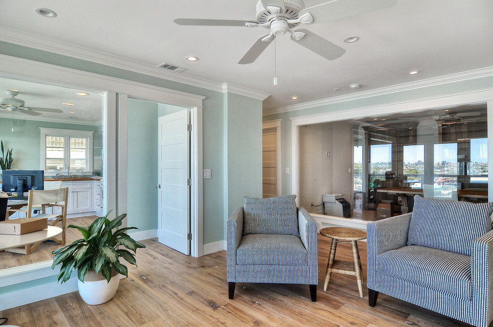 Mid-sized beach style enclosed medium tone wood floor and brown floor living room photo in Orange County with green walls and no fireplace