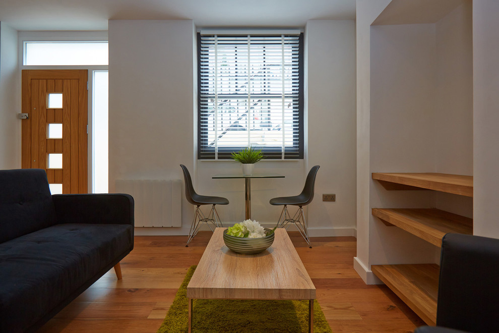 Идея дизайна: маленькая открытая гостиная комната в современном стиле с белыми стенами и полом из ламината для на участке и в саду