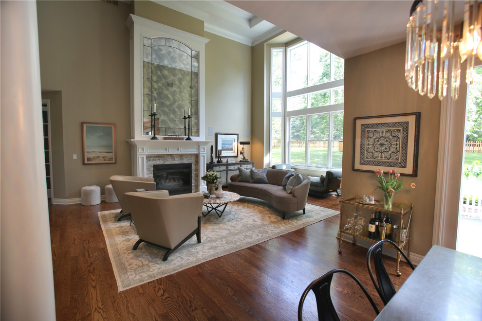 Cette photo montre un grand salon chic ouvert avec un mur beige, un sol en bois brun, une cheminée standard, un manteau de cheminée en pierre, un sol marron, une salle de réception et un plafond décaissé.