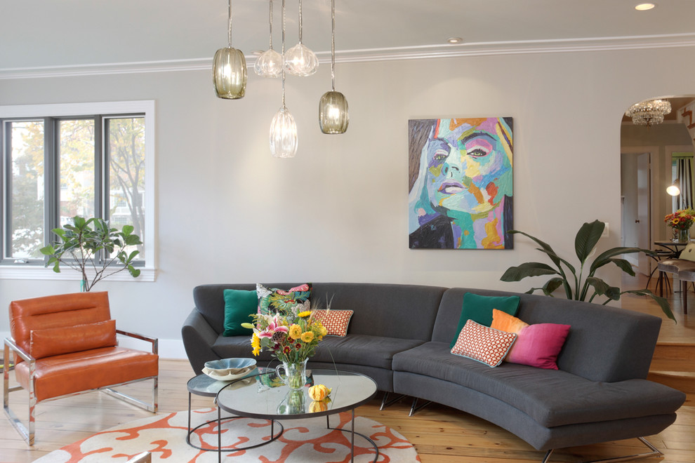 Immagine di un soggiorno minimalista di medie dimensioni e aperto con pareti grigie, parquet chiaro, camino classico, cornice del camino in metallo e parete attrezzata