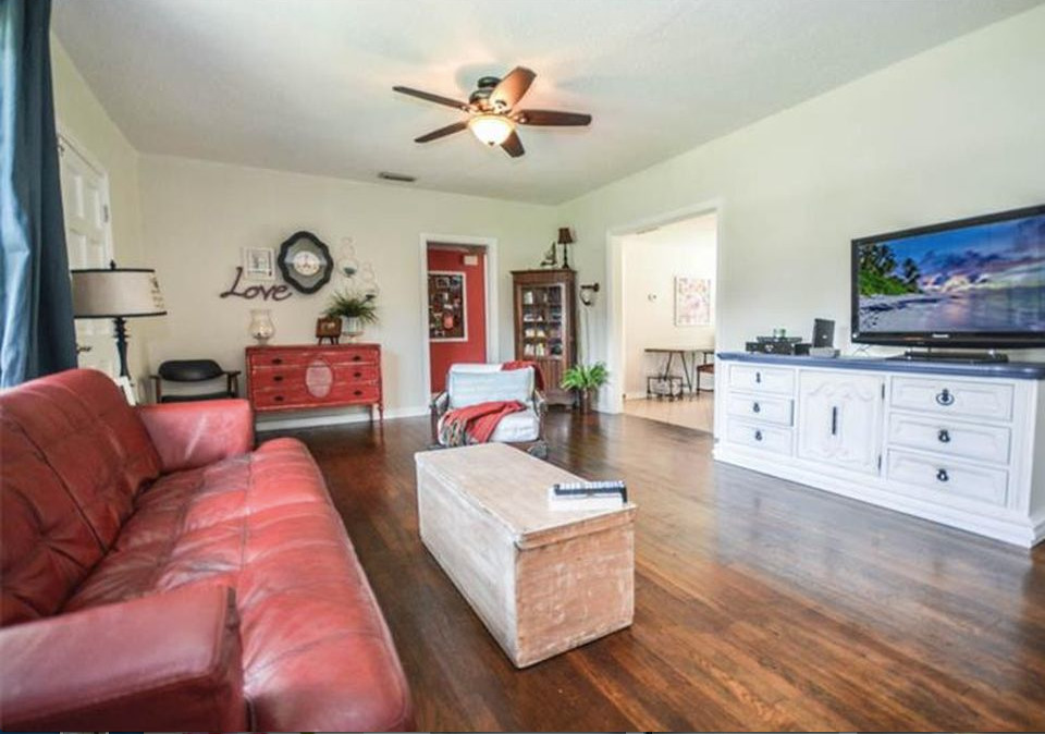 Example of a mid-sized classic open concept dark wood floor and brown floor living room design in Tampa with gray walls and a tv stand