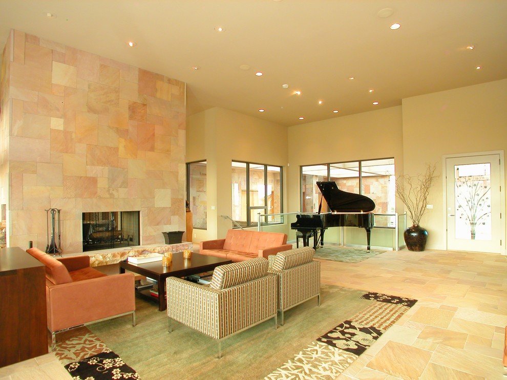 デンバーにあるラグジュアリーな広いコンテンポラリースタイルのおしゃれなLDK (ミュージックルーム、黄色い壁、標準型暖炉、ライムストーンの床、石材の暖炉まわり) の写真