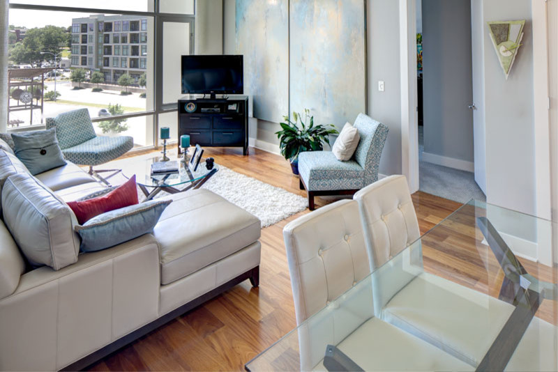 Example of a small trendy open concept light wood floor living room design in Austin with gray walls and a corner tv