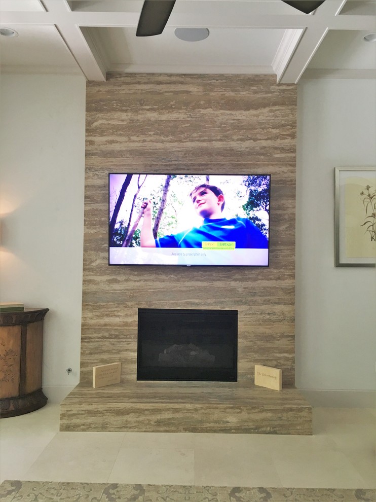 ヒューストンにあるお手頃価格の中くらいなコンテンポラリースタイルのおしゃれなLDK (標準型暖炉、石材の暖炉まわり、壁掛け型テレビ、トラバーチンの床) の写真