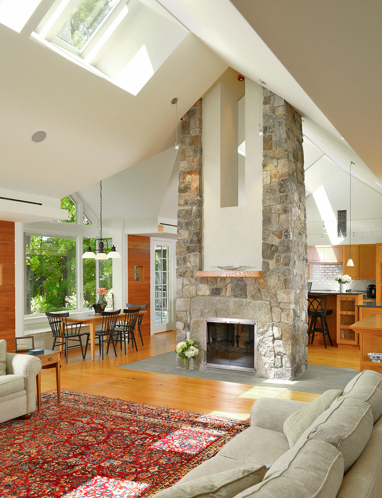 Living room - transitional open concept living room idea in Boston with a two-sided fireplace and a stone fireplace
