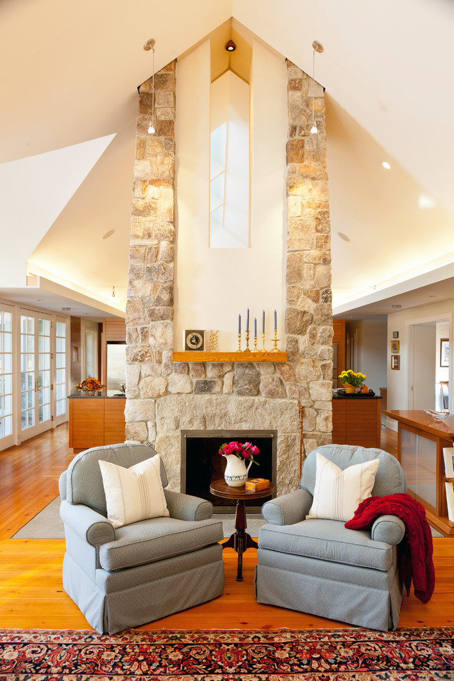 Idée de décoration pour un salon champêtre ouvert avec un mur beige, un sol en bois brun, une cheminée standard et un manteau de cheminée en pierre.