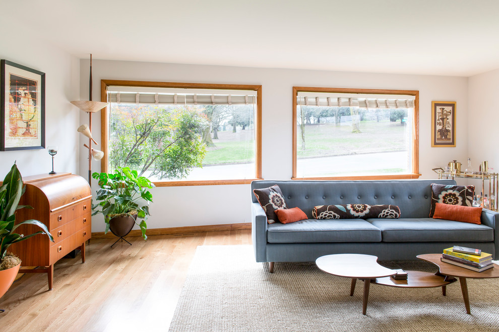Idee per un soggiorno minimalista di medie dimensioni e aperto con pareti bianche, pavimento in legno massello medio, camino bifacciale, cornice del camino in mattoni e TV nascosta
