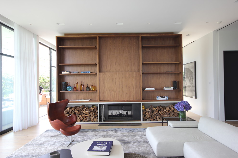 Bild på ett funkis vardagsrum, med vita väggar, ljust trägolv, en standard öppen spis och en dold TV