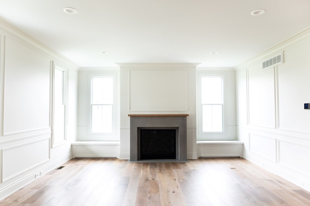 グランドラピッズにあるコンテンポラリースタイルのおしゃれなリビング (白い壁、淡色無垢フローリング、標準型暖炉、コンクリートの暖炉まわり、白い床) の写真