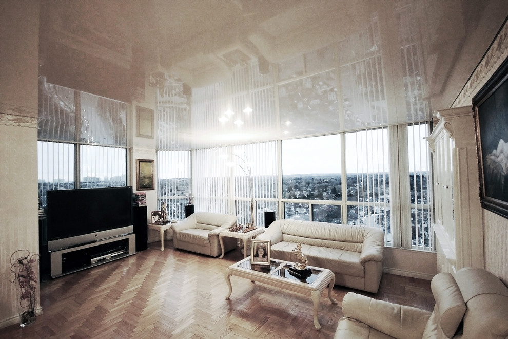 Foto de salón abierto actual de tamaño medio sin chimenea con paredes beige, suelo de madera clara y televisor independiente
