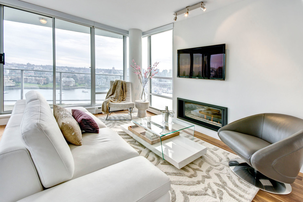 Esempio di un soggiorno minimalista con pareti bianche, camino lineare Ribbon e TV a parete