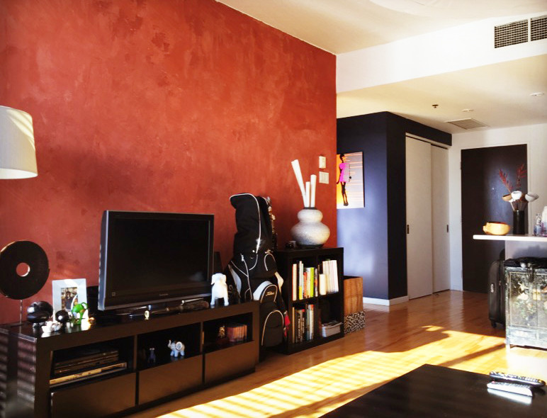 Cette image montre un salon bohème de taille moyenne et ouvert avec une salle de réception, un mur rouge, parquet clair, aucune cheminée, un téléviseur indépendant et un sol beige.