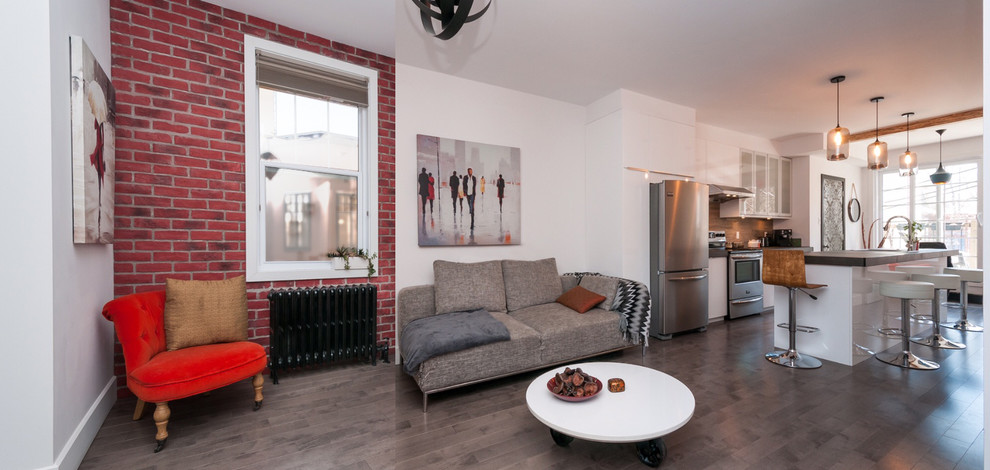 Esempio di un piccolo soggiorno design aperto con libreria, pareti rosse e pavimento in legno massello medio