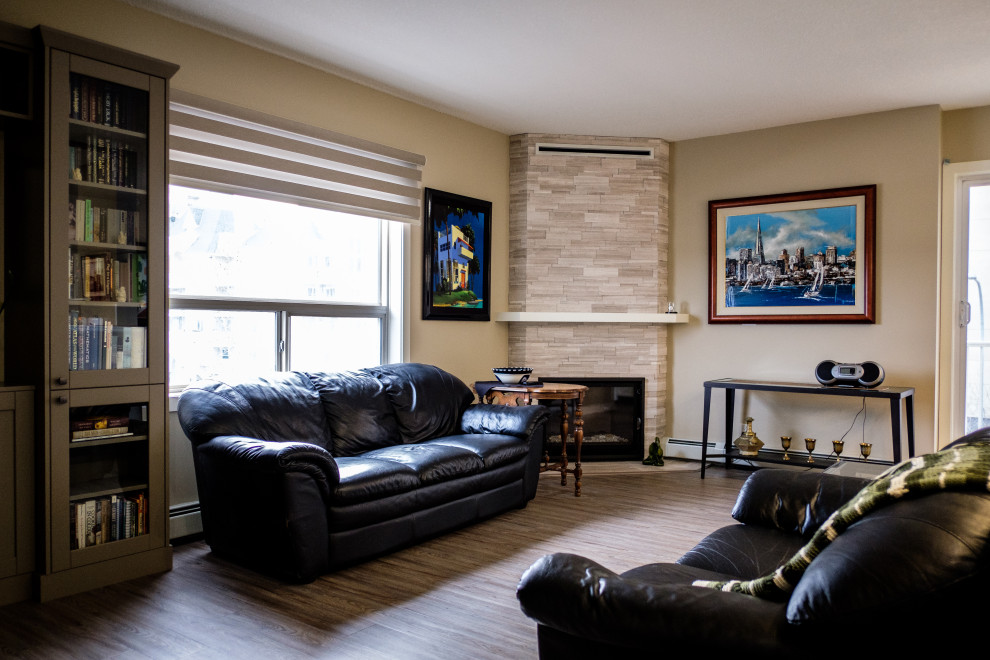 Klassisk inredning av ett mellanstort vardagsrum, med beige väggar, vinylgolv, en öppen hörnspis, en spiselkrans i trä och flerfärgat golv