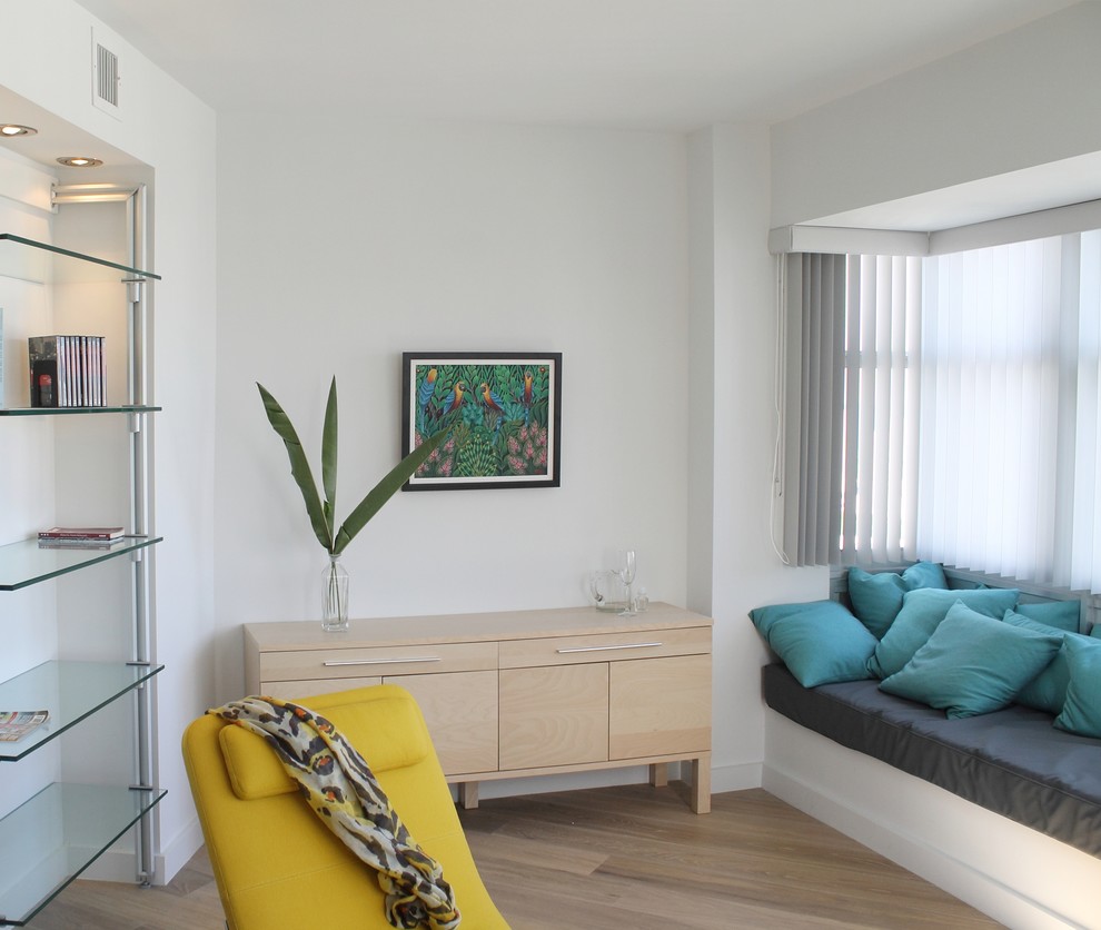 Modelo de salón abierto minimalista pequeño sin chimenea con paredes blancas y suelo de madera en tonos medios