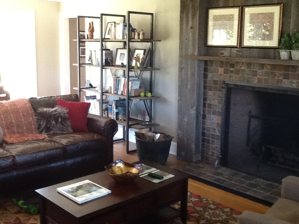 Großes, Offenes Eklektisches Wohnzimmer mit grauer Wandfarbe, braunem Holzboden, Eckkamin und Kaminumrandung aus Stein in New York